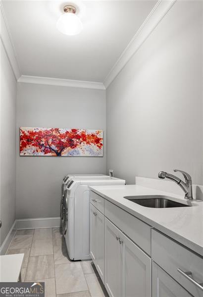 127 Oak Ln, Decatur, GA 30030 - laundry area featuring ornamental molding, cabinet space, washer and clothes dryer, and light marble finish floors