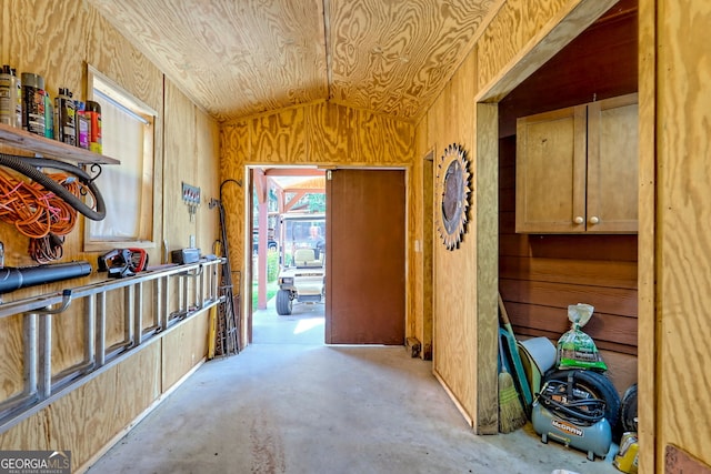 77 Falls View Dr, Dillard, GA 30537 - corridor featuring vaulted ceiling, wood walls, and unfinished concrete flooring