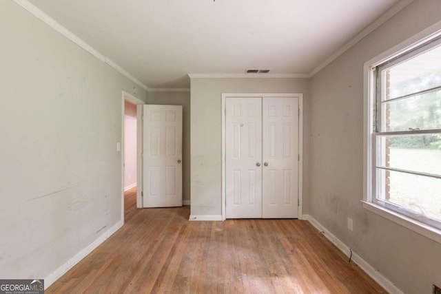 4201 Hicks Rd, Austell, GA 30106 - unfurnished bedroom featuring a closet, light wood-style floors, and crown molding