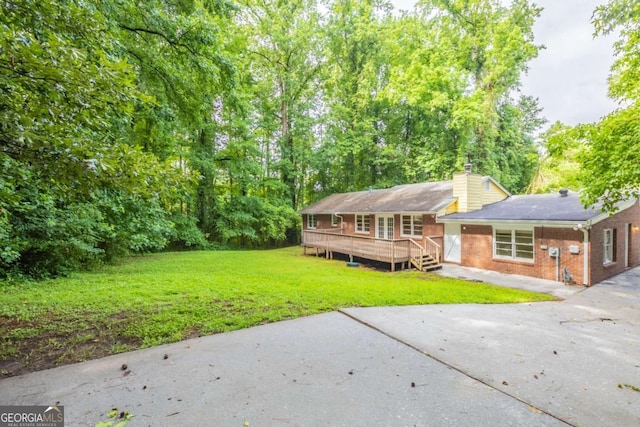 4201 Hicks Rd, Austell, GA 30106 - back of house with a lawn, brick siding, a chimney, and a wooden deck