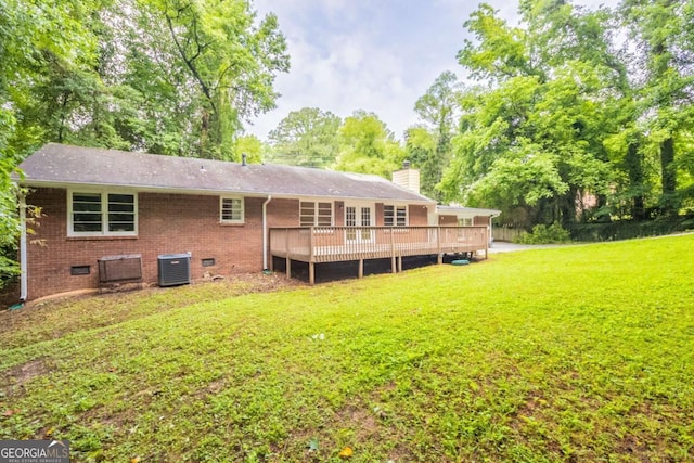 4201 Hicks Rd, Austell, GA 30106 - rear view of house featuring a chimney, a lawn, a deck, brick siding, and view of wooded area