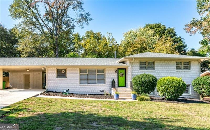 1151 Bromley, Avondale, GA 30002 - split level home with a front lawn, concrete driveway, brick siding, and a carport