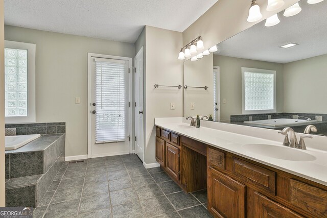 118 Whitfield Run, Peachtree City, GA 30269 - bathroom featuring double vanity, a bath, healthy amount of natural light, and a textured ceiling