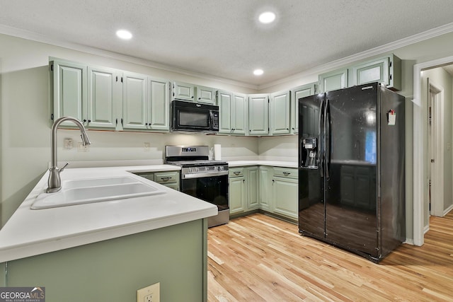 118 Whitfield Run, Peachtree City, GA 30269 - kitchen with black appliances, ornamental molding, light countertops, light wood-type flooring, and green cabinets