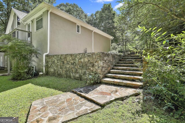 118 Whitfield Run, Peachtree City, GA 30269 - view of side of home featuring stucco siding, stone siding, stairs, and a lawn