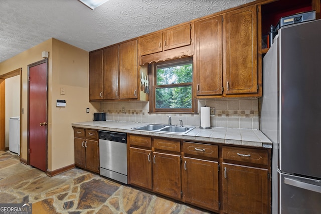 1290 Shadowlawn Dr NE, Conyers, GA 30012 - kitchen with appliances with stainless steel finishes, stone finish flooring, tasteful backsplash, light countertops, and a textured ceiling