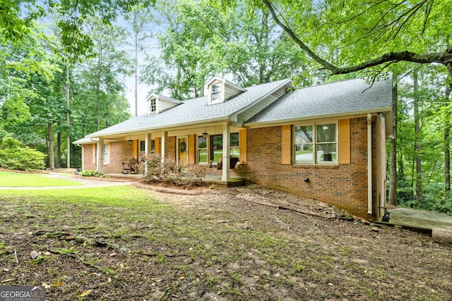 1290 Shadowlawn Dr NE, Conyers, GA 30012 - view of front of house with brick siding, a porch, roof with shingles, and a front yard