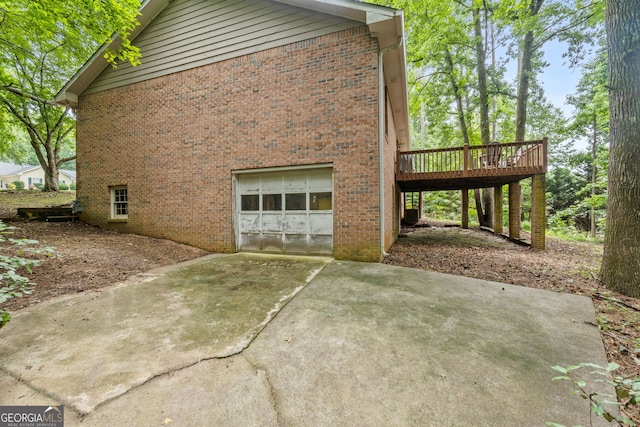 1290 Shadowlawn Dr NE, Conyers, GA 30012 - view of side of property with a garage, brick siding, a wooden deck, and concrete driveway