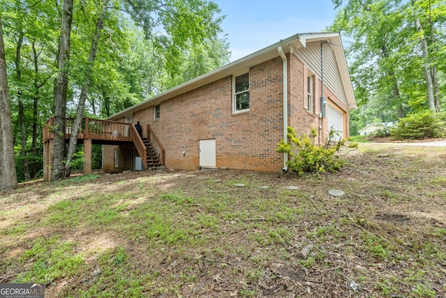 1290 Shadowlawn Dr NE, Conyers, GA 30012 - back of house featuring stairs, brick siding, a wooden deck, and a garage