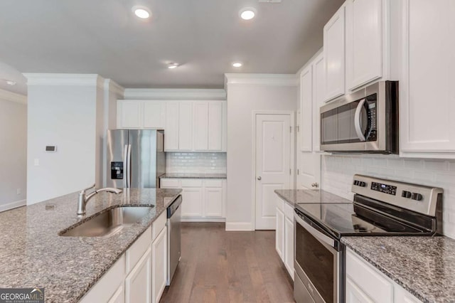 2005 Hamilton Creek Pkwy, Dacula, GA 30019 - kitchen featuring appliances with stainless steel finishes, crown molding, tasteful backsplash, white cabinets, and light stone countertops