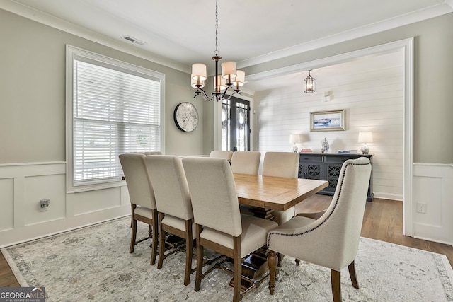 459 N Cove Dr, Newnan, GA 30263 - dining space featuring a chandelier, healthy amount of natural light, crown molding, wood finished floors, and a wainscoted wall