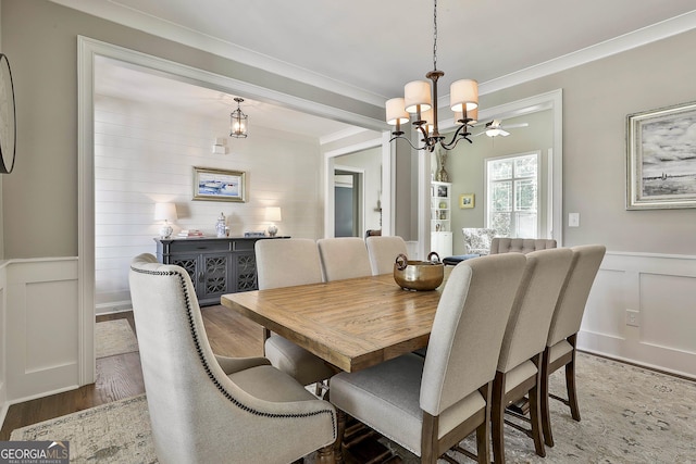 459 N Cove Dr, Newnan, GA 30263 - dining area with a decorative wall, wood finished floors, ornamental molding, a chandelier, and wainscoting