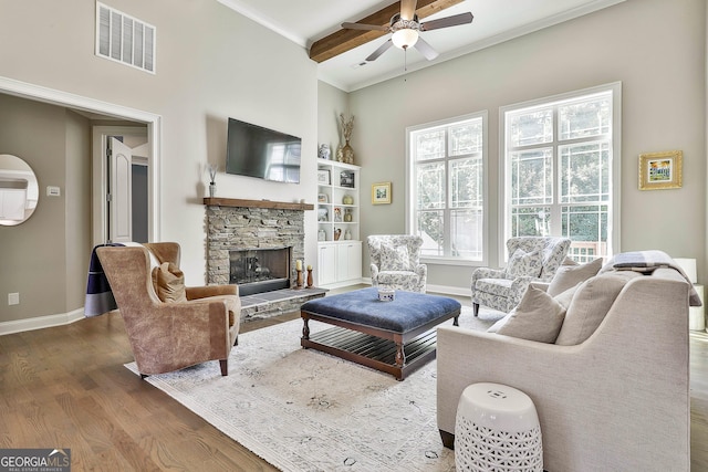 459 N Cove Dr, Newnan, GA 30263 - living room with a ceiling fan, wood finished floors, a stone fireplace, crown molding, and a towering ceiling