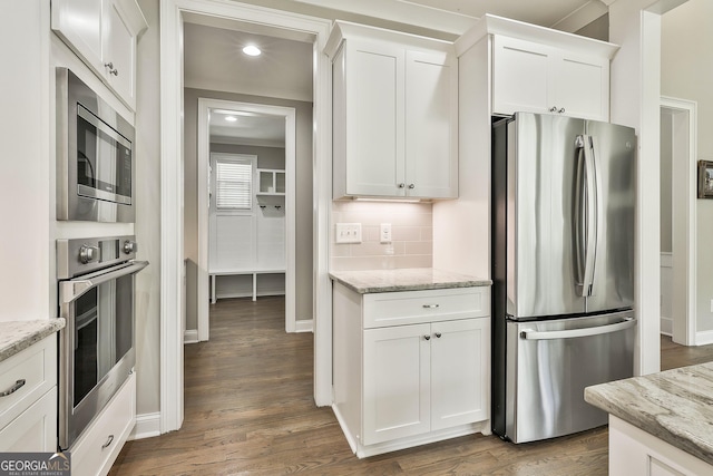 459 N Cove Dr, Newnan, GA 30263 - kitchen featuring appliances with stainless steel finishes, white cabinetry, dark wood-style floors, light stone counters, and recessed lighting