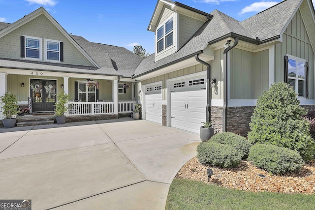 459 N Cove Dr, Newnan, GA 30263 - view of front of home with board and batten siding, a porch, concrete driveway, a shingled roof, and stone siding