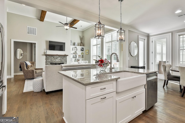 459 N Cove Dr, Newnan, GA 30263 - kitchen with a fireplace, light stone countertops, stainless steel dishwasher, a ceiling fan, and hanging light fixtures