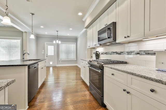 459 N Cove Dr, Newnan, GA 30263 - kitchen with appliances with stainless steel finishes, decorative backsplash, ornamental molding, wood finished floors, and white cabinets