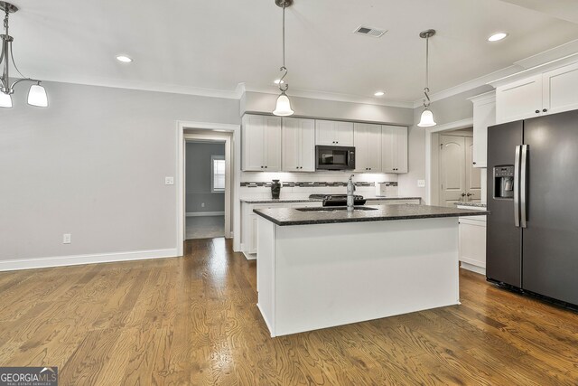 459 N Cove Dr, Newnan, GA 30263 - kitchen with stainless steel refrigerator with ice dispenser, black microwave, white cabinetry, a center island with sink, and ornamental molding