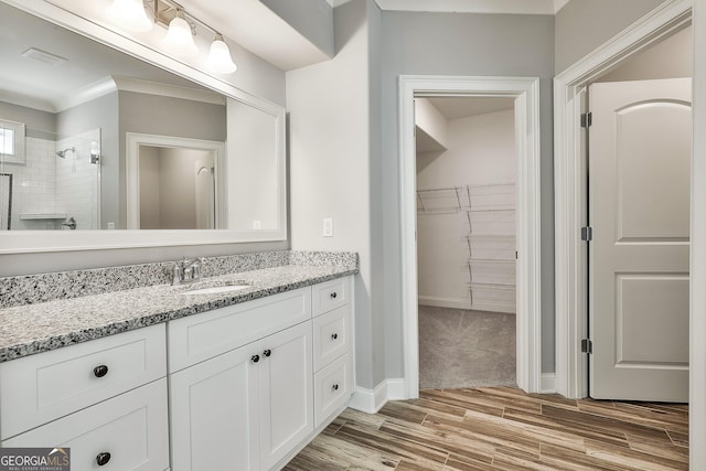 459 N Cove Dr, Newnan, GA 30263 - bathroom with vanity, wood finished floors, a walk in closet, and a tile shower