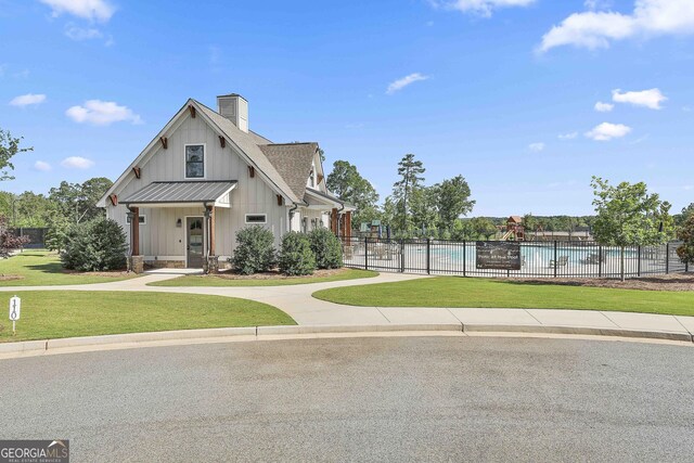 459 N Cove Dr, Newnan, GA 30263 - view of front of house featuring board and batten siding, a community pool, and a chimney