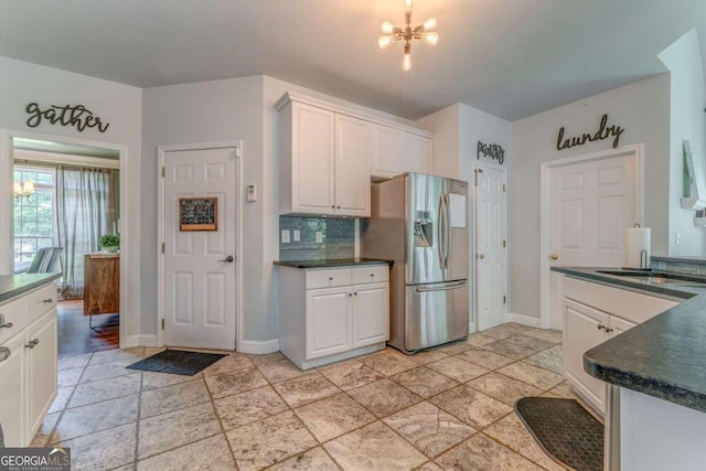 119 Creekside Vw, Hiram, GA 30141 - kitchen with stainless steel refrigerator with ice dispenser, dark countertops, a chandelier, and white cabinets