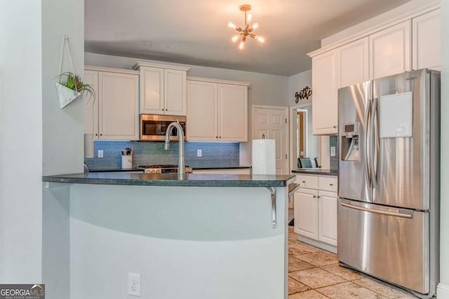 119 Creekside Vw, Hiram, GA 30141 - kitchen with stainless steel appliances, dark countertops, tasteful backsplash, a peninsula, and a chandelier
