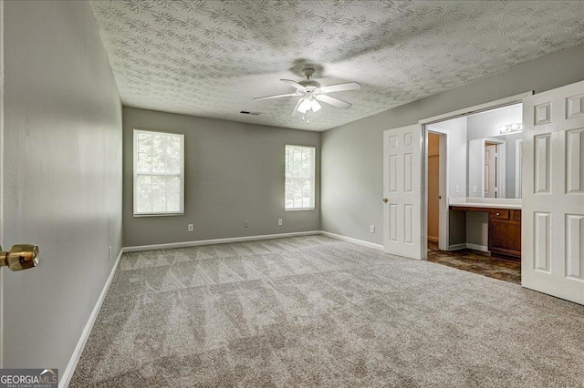 2898 Cedar Trace Dr, Ellenwood, GA 30294 - unfurnished bedroom with carpet flooring, multiple windows, a textured ceiling, connected bathroom, and ceiling fan