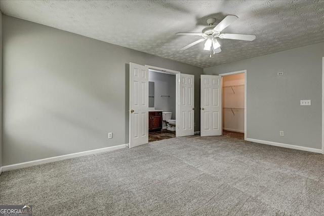2898 Cedar Trace Dr, Ellenwood, GA 30294 - unfurnished bedroom featuring a spacious closet, carpet flooring, a closet, ensuite bathroom, and a textured ceiling