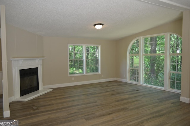 325 High Rd, Forsyth, GA 31029 - unfurnished living room featuring wood finished floors, a textured ceiling, and a glass covered fireplace