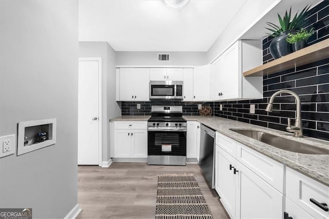 3091 Colonial Way Unit E4, Chamblee, GA 30341 - kitchen featuring stainless steel appliances, backsplash, white cabinets, open shelves, and light stone countertops
