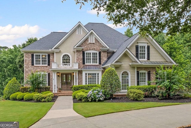 7615 Laurel Oak Dr, Suwanee, GA 30024 - view of front of house featuring a front yard, brick siding, roof with shingles, and a standing seam roof