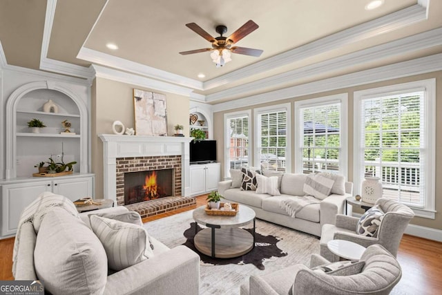 7615 Laurel Oak Dr, Suwanee, GA 30024 - living room with a tray ceiling, built in features, healthy amount of natural light, ceiling fan, and ornamental molding