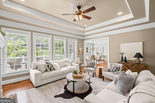 7615 Laurel Oak Dr, Suwanee, GA 30024 - living area featuring a raised ceiling, light wood finished floors, a ceiling fan, crown molding, and recessed lighting