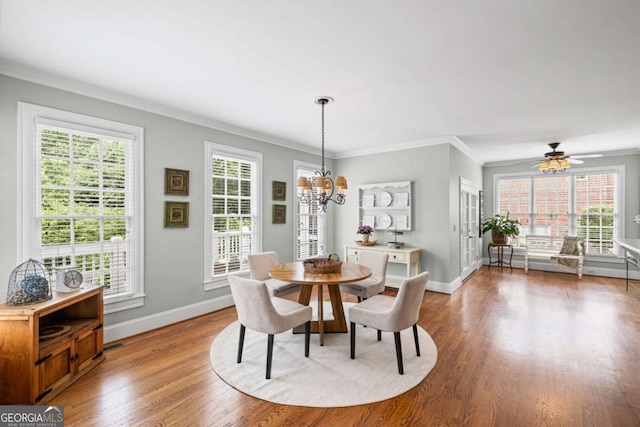 7615 Laurel Oak Dr, Suwanee, GA 30024 - dining room featuring a chandelier, wood finished floors, healthy amount of natural light, ornamental molding, and a ceiling fan