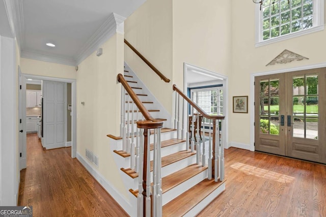 7615 Laurel Oak Dr, Suwanee, GA 30024 - foyer with french doors, plenty of natural light, stairs, wood finished floors, and crown molding