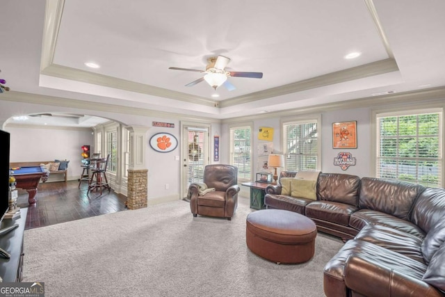 7615 Laurel Oak Dr, Suwanee, GA 30024 - carpeted living room featuring a raised ceiling, ornate columns, arched walkways, ceiling fan, and ornamental molding