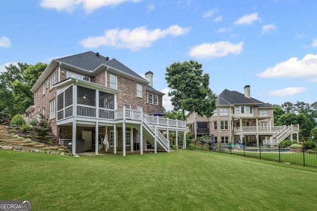 7615 Laurel Oak Dr, Suwanee, GA 30024 - back of house featuring stairs, a sunroom, brick siding, a wooden deck, and a chimney