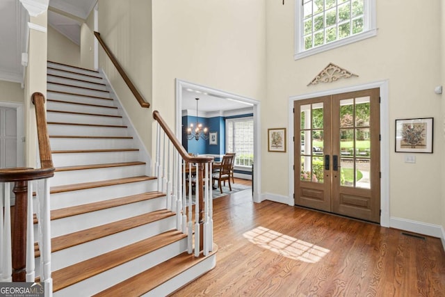 7615 Laurel Oak Dr, Suwanee, GA 30024 - foyer with a towering ceiling, stairway, french doors, a chandelier, and wood finished floors