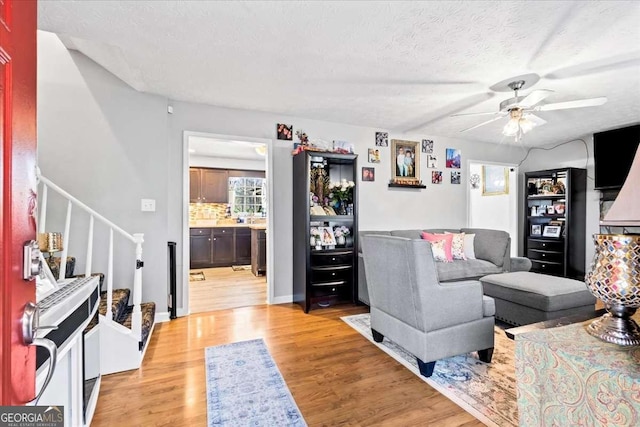 916 Marshall Fuller Rd, Dallas, GA 30157 - living area featuring a ceiling fan, stairs, light wood-type flooring, and a textured ceiling