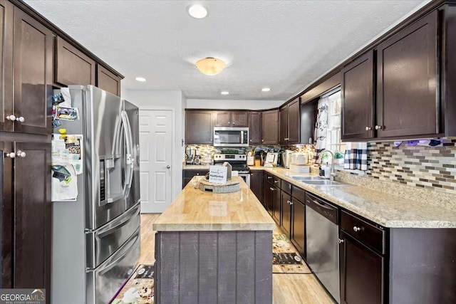 916 Marshall Fuller Rd, Dallas, GA 30157 - kitchen with appliances with stainless steel finishes, dark brown cabinetry, tasteful backsplash, a kitchen island, and wood counters
