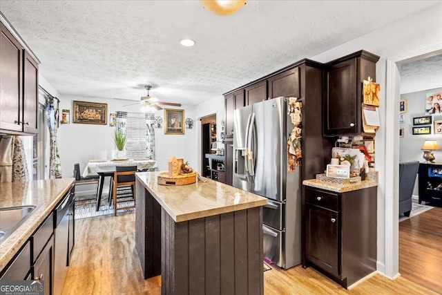916 Marshall Fuller Rd, Dallas, GA 30157 - kitchen with appliances with stainless steel finishes, a kitchen island, a textured ceiling, light wood finished floors, and dark brown cabinetry