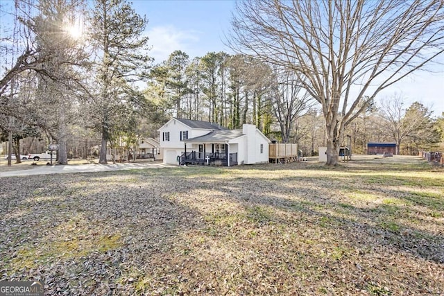 916 Marshall Fuller Rd, Dallas, GA 30157 - view of side of property with an attached garage, a porch, concrete driveway, and a chimney