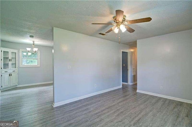 24 Echo Ridge Dr, Powder Springs, GA 30127 - spare room featuring wood finished floors, a textured ceiling, a ceiling fan, and a chandelier