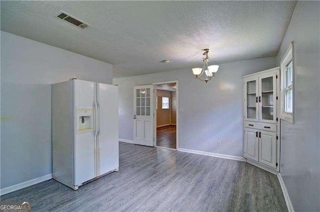 24 Echo Ridge Dr, Powder Springs, GA 30127 - kitchen with white refrigerator with ice dispenser, wood finished floors, a textured ceiling, a chandelier, and white cabinets