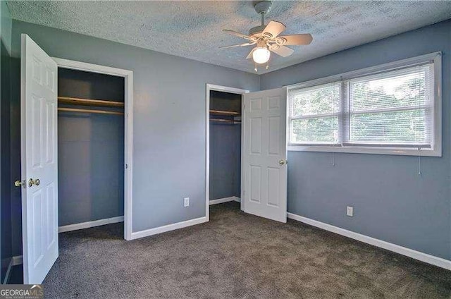 24 Echo Ridge Dr, Powder Springs, GA 30127 - unfurnished bedroom with two closets, a textured ceiling, carpet, and ceiling fan