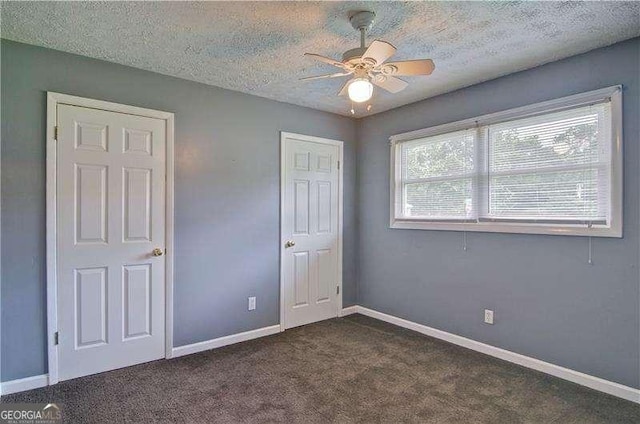 24 Echo Ridge Dr, Powder Springs, GA 30127 - unfurnished bedroom with a textured ceiling, dark carpet, and ceiling fan