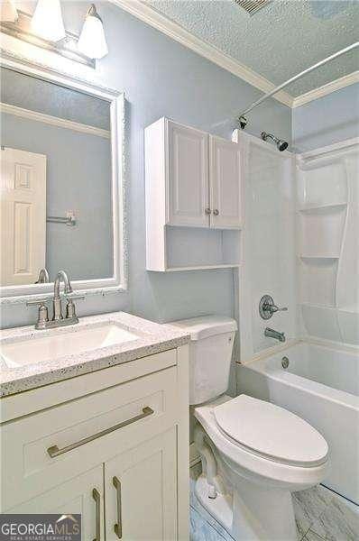 24 Echo Ridge Dr, Powder Springs, GA 30127 - full bathroom featuring crown molding, vanity, washtub / shower combination, and a textured ceiling