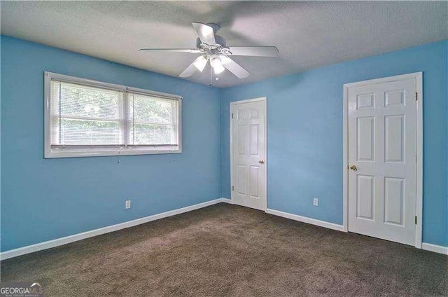 24 Echo Ridge Dr, Powder Springs, GA 30127 - unfurnished bedroom with a textured ceiling, dark carpet, a ceiling fan, and a closet