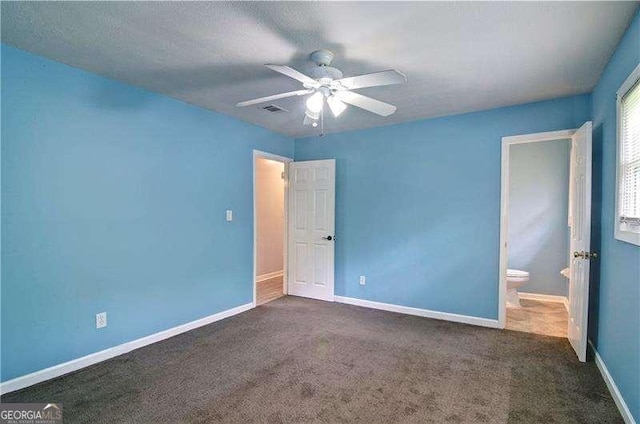 24 Echo Ridge Dr, Powder Springs, GA 30127 - unfurnished bedroom with dark carpet, a ceiling fan, and connected bathroom
