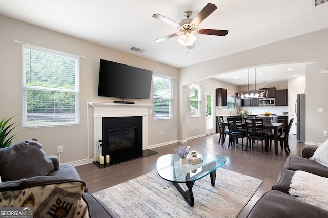 207 Cross Rd, Acworth, GA 30102 - living area featuring a ceiling fan, dark wood finished floors, a glass covered fireplace, arched walkways, and recessed lighting